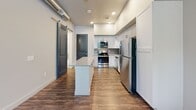 Located at 532 W Colorado Ave in Colorado Springs, Colorado, this single-floor unit offers a clean, modern aesthetic with thoughtfully selected finishes throughout. The kitchen serves as a functional centerpiece, showcasing white shaker-style cabinetry, granite countertops, a light blue subway tile backsplash, and a full suite of stainless steel appliances including a refrigerator, electric range, and over-the-range microwave. Wood-look flooring runs through the kitchen and connects seamlessly to the adjacent areas, lending warmth and continuity to the open layout. The bathroom continues the refined design language with white cabinetry, granite countertops, a large vanity mirror, and recessed lighting, creating a clean and functional space. The bedroom features plush carpeting, a ceiling fan, and multiple windows dressed with horizontal blinds that allow for ample natural light while maintaining privacy. The unit's neutral color palette of soft whites and warm grays provides a versatile backdrop throughout. A bold navy blue entry door adds a distinctive accent upon arrival. The 3D dollhouse view reveals a compact yet efficiently arranged floor plan, with the kitchen, bathroom, and bedroom logically connected for ease of living.