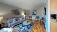 Located at 1700 Street Rd in Warrington, PA, this single-floor residence offers a well-organized and functional layout throughout. The living room is a welcoming space featuring classic parquet hardwood flooring, neutral-toned walls, and multiple windows that allow natural light to fill the room. The open sightline to the dining area creates a cohesive flow between entertaining spaces.

The kitchen is efficiently designed with a galley-style layout, featuring light wood cabinetry, granite countertops, a mosaic tile backsplash, and black appliances including a gas range and full-size refrigerator. Tile flooring completes the kitchen's practical finish.

The bedrooms continue the parquet hardwood flooring found throughout the home. The primary bedroom is generously sized with natural light from a window, dual closets offering ample storage, and a softly accented accent wall. An additional bedroom also benefits from natural light and parquet floors.

The bathroom is neatly appointed with tile flooring, a vanity with under-cabinet storage, an oval mirror, and a wall-mounted cabinet for additional organization.

Throughout the residence, parquet hardwood floors provide a warm and consistent aesthetic, while neutral wall tones create a versatile backdrop. The overall layout is practical, well-connected, and comfortable for everyday living.