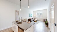 Located on Old Monrovia Rd NW in Huntsville, Alabama, this contemporary single-floor residence showcases a thoughtfully designed open-concept layout that seamlessly connects the kitchen, dining, and living areas. The kitchen is a standout feature, outfitted with crisp white shaker cabinetry, subway tile backsplash, stainless steel appliances, and a generous island with quartz countertops and bar seating — ideal for both everyday cooking and entertaining. Pendant lighting adds a refined touch overhead. The living area benefits from natural light streaming through large windows and offers soaring ceiling heights that amplify the sense of space. Wood-look flooring runs throughout the main living areas, transitioning to plush carpet in the bedrooms. The primary bedroom is generously proportioned with high ceilings, a walk-in closet, and access to a private bathroom featuring a glass-enclosed walk-in shower with herringbone tile detailing. An in-unit stacked washer and dryer add everyday convenience. The secondary bedroom is well-sized with a bright window and ample room. Throughout, the neutral color palette, clean lines, and modern finishes create a bright, welcoming atmosphere that is both functional and stylish.