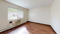 This two-floor property on Taylor Street in Franklin, Pennsylvania offers a practical and straightforward layout across both levels. The kitchen is well-equipped, featuring rich dark wood cabinetry extending to the ceiling for generous storage, stone-toned countertops, and white appliances including a gas range, over-the-range microwave, dishwasher, and refrigerator. Natural light filters in through a window near the exterior door, and wood-style flooring runs throughout the kitchen and main living areas, adding warmth to the space.

The living areas benefit from large windows fitted with vertical and horizontal blinds, allowing for ample natural light while maintaining privacy. Wall-mounted climate control units and baseboard heating are present throughout, ensuring year-round comfort. Several rooms feature plush carpeting, providing a softer feel underfoot, while other areas continue the wood-style flooring.

Bedrooms are generously sized with neutral cream-toned walls and are equipped with built-in bi-fold closets, including rooms with double closet configurations for enhanced storage. The bathroom includes a full tub and shower combination with chrome fixtures and a grab bar. Overall, the space presents a clean, functional environment suitable for comfortable everyday living.