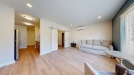 Located at 410 Washington Ave in North Haven, Connecticut, this thoughtfully designed single-floor unit offers an efficient and modern living experience across six distinct spaces. Light-toned luxury vinyl plank flooring runs throughout, creating a cohesive and clean aesthetic.

The open living and dining area serves as the heart of the unit, featuring recessed lighting, a wall-mounted mini-split HVAC system, and a striking pair of sliding barn doors that add a contemporary architectural touch. A large window with a teal accent wall anchors the living space, allowing natural light and outdoor views to enhance the room's ambiance.

The galley-style kitchen is well-appointed with two-tone cabinetry, granite countertops, a white subway tile backsplash, stainless steel appliances including a refrigerator, dishwasher, and range, and a undermount sink with a modern gooseneck faucet. Adjacent to the kitchen is a compact dining area with flush-mount ceiling lighting.

The bedroom is bright and open with neutral tones and clean white baseboards. The bathroom features a walk-in shower with floor-to-ceiling white subway tile, a frameless sliding glass door, chrome fixtures, and an integrated grab bar, reflecting both style and accessibility. The unit combines practical design with modern finishes throughout.