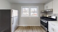 Located at 251 Seneca Dr in Syracuse, NY, this thoughtfully renovated single-floor home offers a clean, modern aesthetic carried consistently throughout every room. Light-toned luxury vinyl plank flooring runs seamlessly across the living areas, bedrooms, and kitchen, creating a cohesive and easy-to-maintain interior.

The spacious living room is bathed in natural light through a large picture window overlooking the neighborhood, and features recessed ceiling lighting for a polished finish. The kitchen is well-appointed with crisp white shaker cabinetry, light stone countertops, a subway tile backsplash, a stainless steel undermount sink, and a stainless steel gas range with an overhead exhaust hood. A stainless steel refrigerator and dual windows complete the functional and bright culinary space.

The bedrooms are generously sized, each finished with the same neutral gray walls and vinyl plank flooring. Multiple windows in the bedrooms invite ample natural light and offer views of the surrounding greenery. Closet access is included in the bedroom areas.

The bathroom is finished with large-format marble-look tile covering both the floors and walls, lending a clean and elevated feel. It includes a soaking tub with shower, a modern vanity with under-cabinet storage, and a window for natural ventilation. The home's neutral color palette and updated finishes create a bright, move-in-ready atmosphere throughout.