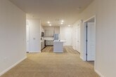 Located at 4225 East West Connector in Smyrna, Georgia, this single-floor unit offers a thoughtfully designed open-concept layout that seamlessly connects the living and kitchen areas. The kitchen is a standout feature, showcasing gray shaker-style cabinetry, crisp white quartz countertops, and a suite of stainless steel appliances including a range, over-the-range microwave, and refrigerator. A central island with an integrated sink adds both prep space and a natural gathering point, anchoring the open floor plan. Wood-look luxury vinyl plank flooring runs throughout the kitchen and wet areas, providing a warm, durable foundation.

The living area flows naturally from the kitchen, featuring plush neutral carpet and a ceiling fan, creating a comfortable and inviting atmosphere. The bedrooms are generously sized, each with soft carpeting, large windows that invite natural light and neighborhood views, and ample wall space. The bathroom is finished with matching gray vanity cabinetry, white quartz countertops, wood-look flooring, and a subway-tiled tub and shower surround. A walk-in closet adjacent to the bathroom adds convenient storage. Throughout the unit, a consistent neutral color palette and recessed lighting create a clean, modern ambiance.