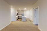 Located at 4225 East West Connector in Smyrna, Georgia, this single-floor unit offers a thoughtfully designed open-concept layout that seamlessly connects the living and kitchen areas. The kitchen is a standout feature, showcasing gray shaker-style cabinetry, crisp white quartz countertops, and a suite of stainless steel appliances including a range, over-the-range microwave, and refrigerator. A central island with an integrated sink adds both prep space and a natural gathering point, anchoring the open floor plan. Wood-look luxury vinyl plank flooring runs throughout the kitchen and wet areas, providing a warm, durable foundation.

The living area flows naturally from the kitchen, featuring plush neutral carpet and a ceiling fan, creating a comfortable and inviting atmosphere. The bedrooms are generously sized, each with soft carpeting, large windows that invite natural light and neighborhood views, and ample wall space. The bathroom is finished with matching gray vanity cabinetry, white quartz countertops, wood-look flooring, and a subway-tiled tub and shower surround. A walk-in closet adjacent to the bathroom adds convenient storage. Throughout the unit, a consistent neutral color palette and recessed lighting create a clean, modern ambiance.