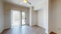 Located at 4900 E Oltorf St in Austin, Texas, this single-floor unit offers a well-designed layout with a cohesive blend of modern finishes and functional living spaces. The kitchen is a standout feature, equipped with stainless steel appliances including a range, microwave, and refrigerator, complemented by sleek white cabinetry, under-cabinet lighting, a dark countertop peninsula with a built-in sink, and light wood-style flooring that adds warmth to the space. Track lighting overhead enhances the kitchen's contemporary aesthetic. The living area is bright and open, featuring light wood-style flooring, a ceiling fan, and a sliding glass door that opens to a private balcony overlooking lush greenery, allowing natural light to flow throughout. The bedroom is carpeted for comfort, fitted with a ceiling fan, and includes a window with blinds that brings in additional natural light. The bathroom features white cabinetry, a dark stone-style countertop with an undermount sink, brushed nickel fixtures, a large framed mirror, and a shower-tub combination. Throughout the unit, neutral tones and clean lines create a cohesive, move-in-ready atmosphere suited for comfortable everyday living in Austin.