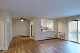 Located at 25 Hopkins Rd in Liverpool, NY, this well-appointed 2-bedroom, 2-bathroom unit offers a thoughtfully designed single-floor layout. The open-concept living and dining area is finished with light-toned hardwood-style flooring and features a ceiling fan, baseboard heating, and a wall-mounted AC unit. Natural light filters through sliding glass door access, adding brightness to the shared living space.

The kitchen is accessible via a pass-through counter with a granite-style surface, offering a functional connection to the main living area. White cabinetry, stainless steel appliances — including a refrigerator, gas range, and dishwasher — and a double-basin sink with a window above round out this practical and attractive kitchen.

Both bedrooms are carpeted and comfortably sized. The primary bedroom is notably spacious and features multiple closets, providing excellent storage capacity. The second bedroom includes a window with natural light. Three closets in total are distributed throughout the unit.

The two bathrooms are clean and functional. One includes a full soaking tub with a white surround, while the other features a white vanity with brushed nickel fixtures and a mirrored medicine cabinet. A hallway connects the main living areas to the bedrooms and bathrooms, completing the efficient floor plan.