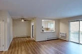 Located at 25 Hopkins Rd in Liverpool, NY, this well-appointed 2-bedroom, 2-bathroom unit offers a thoughtfully designed single-floor layout. The open-concept living and dining area is finished with light-toned hardwood-style flooring and features a ceiling fan, baseboard heating, and a wall-mounted AC unit. Natural light filters through sliding glass door access, adding brightness to the shared living space.

The kitchen is accessible via a pass-through counter with a granite-style surface, offering a functional connection to the main living area. White cabinetry, stainless steel appliances — including a refrigerator, gas range, and dishwasher — and a double-basin sink with a window above round out this practical and attractive kitchen.

Both bedrooms are carpeted and comfortably sized. The primary bedroom is notably spacious and features multiple closets, providing excellent storage capacity. The second bedroom includes a window with natural light. Three closets in total are distributed throughout the unit.

The two bathrooms are clean and functional. One includes a full soaking tub with a white surround, while the other features a white vanity with brushed nickel fixtures and a mirrored medicine cabinet. A hallway connects the main living areas to the bedrooms and bathrooms, completing the efficient floor plan.