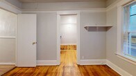 Located at 1126 SW 12th Ave in Portland's vibrant SW neighborhood, this cozy ground-floor unit offers an efficiently designed single-level layout. Warm hardwood floors run throughout the space, complemented by white trim, crown molding details, and textured ceilings that lend a classic character to the interior.

The main living area is open and simply appointed, featuring neutral gray walls, white baseboards, and a functional entry door alongside a small window panel. The kitchen is compact and practical, equipped with a gas range, a single-basin stainless steel sink, a blue laminate countertop, under-counter cabinetry, and a window that allows natural light to filter in.

A dedicated dining area provides a defined space for meals, while the closet offers built-in shelving for organized storage. The bathroom is a notable highlight, showcasing a vintage clawfoot bathtub fitted with a circular shower rod and curtain, chrome fixtures, a toilet, and additional open shelving — a charming nod to classic design.

Throughout the unit, the consistent hardwood flooring and clean white walls create a cohesive, understated aesthetic. This space is well-suited for those seeking a straightforward, character-filled residence in the heart of Portland.