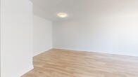 Located on the third floor at 129 Wellington Street in Brantford, Ontario, this 2-bedroom, 1-bathroom unit offers a compact yet efficiently designed layout finished with consistent light wood laminate flooring throughout. The living room is a bright, open space anchored by large sliding glass doors that lead to a balcony, allowing natural light to fill the room while providing views of the surrounding cityscape. The open sightline toward the kitchen and entryway adds to the sense of flow within the unit.

The primary bedroom is a well-proportioned room featuring a wide, floor-to-ceiling sliding closet and a large multi-pane window with baseboard heating beneath it, offering ample natural light and urban views. The second bedroom is similarly finished, with its own window, baseboard heater, and a built-in closet, providing practical storage in a clean, neutral space.

The bathroom is finished with white subway tile surrounding the soaker tub and shower combination, complemented by grey floor tile, a clean white toilet, and simple chrome fixtures — presenting a crisp, functional aesthetic. Throughout the unit, white walls and bright trim maintain a clean, modern appearance, creating a cohesive and move-in ready living environment.