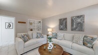 Located at 7575 Bissonnet St in Houston, TX, this single-story, one-bedroom, one-bathroom residence offers a thoughtfully designed layout across a compact yet efficient floor plan. Marble-look porcelain tile flooring flows consistently throughout the home, lending a clean and cohesive aesthetic to every room.

The living room is an inviting, light-filled space featuring neutral gray walls, built-in display shelving, and windows that allow natural light to brighten the area. The adjacent dining room continues the bright, airy feel with a window overlooking the exterior, creating a pleasant space for meals.

The galley-style kitchen is well-equipped, featuring granite countertops, a mosaic tile backsplash, gray cabinetry, and white appliances including a range, dishwasher, and refrigerator. A skylight adds additional natural light to this functional cooking space.

The generously sized primary bedroom offers a ceiling fan, natural light from a window, and access to a dedicated closet. The room comfortably accommodates a full-sized bed and additional furnishings. Two additional closets throughout the unit provide ample storage.

The bathroom features a granite-topped vanity, tiled tub-shower combination, and marble-look tile flooring. A hallway connects the main living areas, completing this well-organized and practical Houston residence.