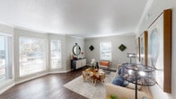 Located at 7510 Brompton St in Houston's 77025 zip code, this single-floor residence offers a well-appointed layout with distinct living, sleeping, and functional spaces throughout. The living room serves as the heart of the home, featuring rich dark hardwood flooring, crown molding, a textured ceiling, and an abundance of natural light streaming through multiple windows fitted with white blinds. The open, airy atmosphere is complemented by neutral gray walls that create a clean, modern backdrop. The galley-style kitchen is efficiently designed with white shaker cabinetry, white quartz countertops, a classic subway tile backsplash, stainless steel appliances, and a double-basin sink. A window above the sink brings in additional natural light. The bedrooms feature plush carpeting and ceiling fans, with the primary bedroom offering sliding door access to the outdoors and ample space for a sizable furniture arrangement. A second bedroom provides a cozy retreat with its own distinct character. The bathroom is finished with large-format tile surrounding a full tub and shower combination, accented by chrome fixtures and a clean, contemporary aesthetic. Throughout the residence, a cohesive design palette of soft grays and warm neutrals ties each space together seamlessly.