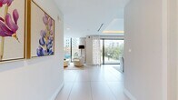 This contemporary office space, located at 345 Banyan Blvd in West Palm Beach, FL, spans 1520 square feet on a single floor. The interior showcases a sleek, modern design with a harmonious blend of functionality and aesthetics. Floor-to-ceiling windows dominate the space, flooding it with natural light and offering panoramic views of the urban landscape.

The office features multiple work areas, including open-plan spaces and glass-partitioned rooms, providing versatility for various work styles. A standout lounge area boasts comfortable white seating arranged around a sculptural coffee table, perfect for casual meetings or relaxation. The color palette is predominantly neutral, with white walls and floors creating a bright, airy ambiance.

The bathroom exemplifies the attention to detail, with a floating vanity, oval mirror, and accessible design elements. Throughout the space, modern lighting fixtures and carefully placed indoor plants add warmth and visual interest. The overall design prioritizes openness and transparency, with glass partitions maintaining sight lines across the office while still allowing for privacy when needed. This thoughtfully designed space seamlessly blends form and function, creating an inspiring environment for modern professionals.