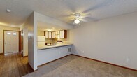 Located at 6680 Oak Bend Commons Way in Columbus, Ohio, this multi-floor home offers 2 bedrooms and 3 bathrooms spread across three levels. The main living floor features a generously sized living room with plush carpeting, a ceiling fan, and a sliding glass door that brings in natural light and provides outdoor access. The adjacent kitchen features an open pass-through layout with a peninsula counter, a stainless steel sink, light countertops, a mix of white and wood-tone cabinetry, and white appliances including a refrigerator and range. A half bathroom with wood-look vinyl flooring and a vanity is also found on this level. Upstairs, the primary bedroom offers comfortable proportions with carpeted floors, a window for natural light, and direct access to a private en-suite bathroom with a vanity and mirror. A second well-sized bedroom with carpet and a window is also located on the upper floor. The lower level includes an attached garage and an unfinished basement with exposed framing, concrete floors, and a dedicated laundry area with washer and dryer hookups, offering significant potential for future customization. Throughout the home, warm wood-tone door trim, textured ceilings, and neutral tones create a cohesive, functional aesthetic.