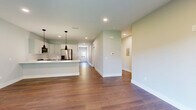 Located at 2 Towpath Rd in Halfmoon, NY, this thoughtfully designed single-floor home offers a clean, modern aesthetic with warm hardwood-style flooring and a neutral color palette throughout. The open-concept kitchen and living area serves as the heart of the home, featuring white shaker cabinetry, light quartz countertops, stainless steel appliances including a gas range, over-the-range microwave, and French door refrigerator, all illuminated by stylish pendant lighting. The living area is bright and inviting, anchored by a sliding glass door that opens to the outdoors and fills the space with natural light. A wide hallway with recessed lighting connects all areas of the home seamlessly. The bedroom is a comfortable, well-proportioned retreat with clean walls and hardwood-style flooring, complemented by two closets — one of which is a generously sized walk-in closet outfitted with wire shelving and hanging storage. The full bathroom features marble-look tile flooring and built-in shelving for added convenience. Additional highlights include a dedicated laundry room, a utility room, and an attached single-car garage with automatic opener and direct interior access, completing this practical and polished home.