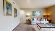 Located at 6000 W 70th St in Shreveport, Louisiana, this 2-bedroom, 1-bathroom residence offers a practical and comfortable single-floor layout thoughtfully designed to maximize its living space. The combined living and dining area serves as the heart of the home, featuring warm neutral-toned carpet, a large window with vertical blinds that invites natural light, and a welcoming entryway accented with a decorative console table and mirror. The living room provides a cozy setting with clean lines and easy access to the hallway and adjacent rooms. The kitchen is equipped with stainless steel appliances, including a full-size refrigerator, white cabinetry with light stone countertops, and wood-look tile flooring that adds a modern touch. The dining area transitions seamlessly from the kitchen, featuring hardwood-style flooring and textured wall detailing with chair rail molding. Both bedrooms are carpeted and offer a restful atmosphere; the primary bedroom features a ceiling fan, a generously sized window for natural light, and ample floor space. The bathroom includes a full-size soaking tub and shower combination with clean white surroundings. A connecting hallway ties all rooms together efficiently, completing this functional and well-maintained home.