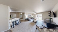 Located at 1950 S Scenic Ave in Springfield, MO, this single-story 2-bedroom, 2-bathroom home offers a well-designed, functional layout across a comfortable footprint. The open living room is carpeted and filled with natural light from a sliding glass door that leads to an outdoor patio, complemented by a ceiling fan overhead. The adjacent dining area features wood-style flooring, providing a seamless transition from the carpeted living space. The kitchen is outfitted with warm wood cabinetry and a breakfast bar with seating, making it ideal for casual dining. Two carpeted hallways connect the main living areas to the private quarters, offering a natural flow throughout. The generously sized primary bedroom benefits from multiple windows that invite abundant natural light and features its own ceiling fan. The two bathrooms are finished with tile flooring and warm wood vanities — one includes a walk-in shower with glass doors, and the other offers a full shower-tub combo. A dedicated laundry room with tile flooring accommodates a full-size washer and dryer. With four closets distributed throughout, storage is plentiful. The neutral color palette and consistent finishes give the entire home a cohesive, move-in-ready feel.