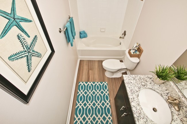 Updated Bathroom with Wood Floors and Granite Countertops - Woodland Park Apartments