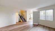 Located in San Diego, CA 92117, this two-story, 3-bedroom, 2-bathroom residence offers a functional and well-designed layout spread across two floors. The main level features a welcoming entryway with light wood-tone flooring that flows throughout, leading into an open living area filled with natural light from a sidelight window flanking the front door. A carpeted staircase with white railings connects the two floors. The kitchen is thoughtfully updated with crisp white shaker cabinetry, granite-look countertops, stainless steel appliances including a range, dishwasher, and refrigerator, and a deep sink—all finished with light wood flooring. The two bathrooms are cleanly appointed; one features a full tub/shower combo with brushed nickel fixtures, while the other includes a white vanity with a mirrored medicine cabinet and brushed nickel hardware. The three bedrooms offer a mix of light wood flooring and plush carpet, with several rooms featuring ceiling fans and multiple windows fitted with vertical blinds that allow ample natural light. The primary bedroom includes mirrored sliding closet doors for added functionality. Throughout the home, neutral tones and clean finishes create a bright, move-in-ready atmosphere ideal for comfortable everyday living.