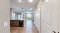 This well-appointed 4-bedroom, 2-bathroom single-story home offers a thoughtfully designed open-concept layout that seamlessly connects the kitchen and living room. The kitchen is a standout feature, showcasing granite countertops, a central island with a built-in sink, rich dark wood cabinetry, pendant lighting, and black appliances including a refrigerator, range, and over-the-range microwave. Wood-style plank flooring runs throughout the main living areas, adding warmth and continuity to the space. The living room is bright and airy, benefiting from multiple windows that invite natural light and a ceiling fan for year-round comfort. French doors provide additional access and light to the living area. Each of the four bedrooms is equipped with a ceiling fan and includes dedicated closet space. The bedrooms feature a mix of wood-style flooring and plush carpeting, catering to comfort and practicality. The bathrooms are finished with wood-toned cabinetry, white countertops, and a tub-shower combination, maintaining the home's consistent neutral color palette. With four closets distributed throughout, storage is both ample and convenient. The overall aesthetic is clean and modern, characterized by neutral tones, consistent finishes, and an efficient single-floor layout.