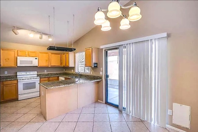 Kitchen and sliding door to the back yard, pet door next to the sliding door - 10608 E Caballero St