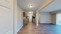 Located at 537 Tranquil Ct in Odenton, Maryland, this two-bedroom, one-bathroom home offers a well-organized single-floor layout with a thoughtful mix of modern finishes and functional living spaces. The kitchen is a standout feature, showcasing gray cabinetry, granite-style countertops, stainless steel appliances including a dishwasher and refrigerator, and durable wood-look flooring that extends into the adjoining areas. The living room is bright and inviting, with large sliding glass doors fitted with vertical blinds that open to a private patio and provide views of the surrounding community and mature trees. The primary bedroom is generously sized, featuring plush carpeting and a double closet with panel doors, while the second bedroom also offers carpeted flooring and a window for natural light. The full bathroom is clean and functional, complete with a tub-shower combination, white tile surround, and a vanity with a white countertop. A dedicated laundry area houses a stacked washer and dryer unit, adding significant convenience. A hallway connects the rooms efficiently throughout the home. The wood-look flooring in the main living areas and kitchen, paired with neutral wall tones throughout, gives the home a cohesive and contemporary feel.