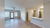 This single-story residence in Baton Rouge, Louisiana offers three bedrooms and two bathrooms within a thoughtfully designed layout. The open-concept living and dining area is finished with light-toned wood-look flooring, crown molding, and a ceiling fan, creating a bright and welcoming atmosphere. Natural light flows in through windows fitted with horizontal blinds, enhancing the neutral gray and white color palette throughout.

The kitchen is equipped with stainless steel appliances, including a refrigerator, range, and over-the-range microwave, complemented by white shaker-style cabinetry with matte black hardware, light quartz countertops, and a gray subway tile backsplash. A peninsula with a built-in sink connects the kitchen to the living area, providing both additional prep space and a casual seating option.

Each bedroom features plush carpeting, a ceiling fan with light fixture, and windows that allow natural light in. The bedrooms offer generous proportions suitable for various furniture arrangements. The bathrooms are finished with white vanity cabinetry, quartz countertops, undermount sinks, and light wood-look tile flooring. A hallway with the same durable flooring as the main living areas connects the bedrooms, contributing to a cohesive and clean aesthetic throughout the home.