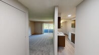 This one-bedroom, one-bathroom unit at 1904 E South Riverton Ave in Spokane, WA offers a practical and well-organized single-floor layout. The galley-style kitchen is a functional highlight, featuring rich dark-wood cabinetry on both sides, light countertops, a stainless steel sink, a dishwasher, a coil-top electric range, and a full-size refrigerator. Recessed lighting and a textured ceiling complete the kitchen's clean, efficient design, while durable wood-look vinyl flooring runs throughout this area. The living space adjoins the kitchen and benefits from a ceiling fan with light fixture, providing both comfort and air circulation. The bedroom offers a generous footprint with soft carpeting, a ceiling fan, a sliding-door closet, and a window with blinds that brings in natural light. A baseboard heater ensures year-round comfort. The bathroom is accessible from the bedroom area and features a vanity with dark cabinetry, a large mirror with overhead lighting, a toilet, and a tub/shower combination with built-in shelving. The bathroom and kitchen areas feature easy-to-maintain vinyl plank flooring. Textured ceilings are consistent throughout the unit, adding a classic residential character to this cozy Spokane home.