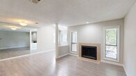 Located in Brookhaven, GA, this one-bedroom, two-bathroom residence offers a well-designed single-floor layout with a neutral, modern aesthetic throughout. The open living room is a welcoming focal point, featuring light-toned hardwood-style flooring, a textured ceiling, and a tile-surround fireplace that adds warmth and character. Large mirrors along one wall visually expand the space, while windows fitted with blinds allow natural light to filter in.

The kitchen is thoughtfully appointed with granite countertops, white cabinetry with brushed gold hardware, stainless steel appliances including an electric range and dishwasher, and a peninsula that provides additional prep and seating space. A tray ceiling adds architectural interest overhead.

The bedroom offers a comfortable and quiet retreat with plush carpet flooring, a ceiling fan, a window with natural light, and a dedicated closet. The two bathrooms continue the granite countertop theme, complemented by white vanity cabinetry and wood-style flooring for a clean, cohesive look.

A dedicated in-unit laundry room houses a full-size washer and dryer with overhead shelving for storage. The entryway provides a practical transition into the home, and the overall layout flows efficiently to maximize everyday functionality.