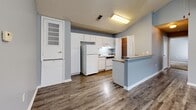 Located at Carraway Commons in Jonesboro, Arkansas, this single-story, 3-bedroom, 1-bathroom home offers a practical and well-organized layout. The interior is unified by a consistent light blue color palette with crisp white trim throughout, creating a clean and cohesive aesthetic.

The kitchen is equipped with white cabinetry, a white refrigerator, and a range, complemented by a peninsula counter that provides additional workspace. Durable wood-look vinyl plank flooring runs through the kitchen and main living areas, adding a modern touch.

All three bedrooms feature soft wall-to-wall carpet and the same neutral blue-gray wall tones. The spacious primary bedroom includes a window for natural light. Two of the three bedrooms feature dedicated closets with built-in shelving, offering practical storage solutions. Each bedroom is served by hallways that connect the rooms efficiently across the single floor.

The bathroom includes a full tub and shower combination with a white surround, set against the home's signature blue-gray walls and wood-look flooring. A textured popcorn ceiling is present throughout the home. With three closets distributed across the floor plan, storage is a notable feature of this residence.