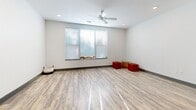 Located at 210 S Main St in Kannapolis, NC, this efficiently designed single-floor unit offers a well-organized layout comprising a living room, kitchen, and full bathroom. Light wood-look flooring runs throughout the space, creating a cohesive and clean aesthetic that enhances the sense of openness.

The kitchen is thoughtfully outfitted with rich dark-stained cabinetry, granite-style countertops, and a full suite of stainless steel appliances, including a refrigerator, dishwasher, and range. Recessed lighting illuminates the space from above, adding a modern, polished finish.

The living area benefits from natural light streaming through a set of horizontal-blind-covered windows, while a ceiling fan with integrated light fixture provides both airflow and additional illumination. Recessed lighting further brightens the room, making it feel airy and inviting despite its compact footprint.

The bathroom maintains the clean, contemporary design language of the rest of the unit, featuring a full-size tub and shower combination with chrome fixtures, white finishes, and wood-look flooring that ties back to the rest of the home.

Overall, this unit presents a modern and functional living environment, well-suited for individuals seeking a streamlined, low-maintenance space in a convenient Kannapolis location.