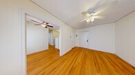 Located at 2226 Garfield Ave S in Minneapolis, Minnesota, this one-bedroom, one-bathroom unit offers a practical and well-organized layout. Warm-toned hardwood floors flow consistently throughout the living spaces, lending a classic character to the interior. The living room provides a welcoming entry point, featuring a ceiling fan with light fixture and access to the rest of the unit. Traditional cast-iron radiators are present in multiple rooms, reflecting the building's established heating system. The bedroom is a comfortable, well-proportioned room with multiple windows that allow natural light to filter in, complemented by its own ceiling fan and a dedicated closet. The kitchen is efficiently arranged with white cabinetry, light countertops, and a double-basin stainless steel sink, offering functional workspace for everyday use. The bathroom is clean and simply appointed, featuring a tiled tub-shower combination, a vanity with sink, and a window for natural ventilation. Throughout the unit, white walls and natural wood floors create a neutral, easy-to-personalize atmosphere. The overall layout is compact yet thoughtfully arranged, making efficient use of the available space.