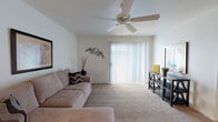 Located at 115 W Limberlost Dr in Tucson, Arizona, this single-story residence offers a well-organized layout designed for comfortable everyday living. The living room serves as the heart of the home, featuring plush carpeting, vaulted ceilings with a ceiling fan, and a large sliding glass door dressed with vertical blinds that floods the space with natural light. The kitchen is efficiently designed with white cabinetry, ample counter space, and a full suite of appliances including an electric range with overhead ventilation. The home includes multiple bedrooms, each carpeted and fitted with ceiling fans for year-round comfort. The primary bedroom is generously proportioned, offering a walk-in closet and a window with vertical blinds that provides natural light. Additional bedrooms are equally well-appointed, with ceiling fans and easy access to shared spaces. The bathroom features a full tub and shower combination, a white vanity with built-in storage drawers, a large mirror cabinet, and wood-look flooring, delivering a clean and practical aesthetic. Throughout the home, neutral tones and consistent finishes create a cohesive and inviting atmosphere well-suited to Tucson's warm desert climate.
