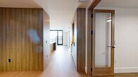Located at 4855 S Quebec St in Denver, CO, this contemporary residence offers a thoughtfully designed single-floor layout with one bedroom, three bathrooms, and a private balcony. The space is defined by a clean, modern aesthetic anchored by light hardwood flooring, crisp white walls, and warm natural wood accents throughout.

The chef's kitchen is a standout feature, showcasing a large waterfall-edge island with an undermount sink, stainless steel professional-grade range, and a sophisticated combination of warm wood and slate-blue cabinetry. Pendant lighting adds an elevated finishing touch over the island.

The spacious bedroom is bathed in natural light through dramatic floor-to-ceiling windows framed in sleek black, offering sweeping elevated views of the Denver skyline, Rocky Mountains, and surrounding cityscape. A private balcony extends the living area outdoors, providing a serene vantage point above the city.

The bathrooms are finished with large-format tile flooring, floating wood vanities with white stone countertops, matte black fixtures, and warm-toned sconce lighting, lending a refined, spa-like quality. A dedicated closet and hallway complete the efficient and well-organized floor plan. The overall ambiance is sophisticated, airy, and modern.