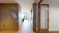 Located at 4855 S Quebec St in Denver, CO, this contemporary residence offers a thoughtfully designed single-floor layout with one bedroom, three bathrooms, and a private balcony. The space is defined by a clean, modern aesthetic anchored by light hardwood flooring, crisp white walls, and warm natural wood accents throughout.

The chef's kitchen is a standout feature, showcasing a large waterfall-edge island with an undermount sink, stainless steel professional-grade range, and a sophisticated combination of warm wood and slate-blue cabinetry. Pendant lighting adds an elevated finishing touch over the island.

The spacious bedroom is bathed in natural light through dramatic floor-to-ceiling windows framed in sleek black, offering sweeping elevated views of the Denver skyline, Rocky Mountains, and surrounding cityscape. A private balcony extends the living area outdoors, providing a serene vantage point above the city.

The bathrooms are finished with large-format tile flooring, floating wood vanities with white stone countertops, matte black fixtures, and warm-toned sconce lighting, lending a refined, spa-like quality. A dedicated closet and hallway complete the efficient and well-organized floor plan. The overall ambiance is sophisticated, airy, and modern.