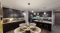 Located in Houston, TX, this single-floor residence showcases a thoughtfully designed interior that blends modern sophistication with everyday comfort. The open-concept kitchen is a standout feature, outfitted with rich dark espresso cabinetry, granite countertops, a subway tile backsplash, and a full suite of stainless steel appliances. A large center island with bar seating offers additional prep space and casual dining, while pendant lighting adds a refined finishing touch. Adjacent to the kitchen, the dining area accommodates a round table with upholstered seating beneath a striking multi-bulb chandelier, creating an inviting atmosphere for meals and gatherings. The living room is anchored by a bold patterned accent wall with decorative wall sconces and flows effortlessly to a private balcony through floor-to-ceiling sliding glass doors, filling the space with natural light and outdoor views. Wide-plank hardwood-style flooring runs throughout the main living areas. The bedroom is a serene retreat with plush carpeting, a tray ceiling, built-in shelving, and a private balcony access. The bathroom features large-format tile flooring, dark vanity cabinetry with granite countertops, a framed mirror, and a soaking tub, completing this well-appointed residence.
