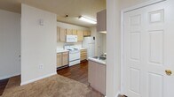 Located at 1907 Spring Garden St in Greensboro, NC, this single-story unit offers a practical and comfortable layout across a well-organized floor plan. The living area is generously sized, featuring neutral-toned carpet that extends throughout the main living and bedroom spaces, creating a cohesive and warm atmosphere. A textured ceiling and flush-mount lighting fixtures are consistent throughout the unit.

The kitchen is designed in a galley style, offering ample cabinetry with light wood finishes on both sides of the corridor. White appliances include an electric range, microwave, and refrigerator. A double-basin stainless steel sink sits opposite the cooking area, and durable wood-look flooring runs through the kitchen, adding contrast to the carpeted adjoining spaces.

The bedrooms are well-proportioned, with one featuring a window that allows natural light and direct access to a full bathroom. The bathrooms include wood-look flooring, a vanity with a mirror, and a tub-shower combination. A secondary bathroom provides a similarly functional layout with a tub and toilet. Throughout the unit, white trim and neutral wall tones contribute to a clean, understated aesthetic.