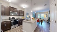 Located at 380 Mather St in Hamden, CT, this single-floor residence offers two bedrooms and two full bathrooms within a thoughtfully designed layout. The kitchen is a standout feature, showcasing rich dark-wood cabinetry, granite countertops, stainless steel appliances, and warm wood-look flooring — all centered around a peninsula with an undermount sink and pendant lighting. The adjacent living room is bright and welcoming, with large windows dressed in white blinds that invite generous natural light and views of the surrounding greenery, complemented by the same durable wood-look flooring. The primary bedroom is a comfortable retreat with plush carpeting, soft gray walls, and a well-sized window that continues the theme of natural light throughout the home. The second bedroom mirrors this warmth, offering carpet flooring, neutral tones, and an oval wall mirror accent. Both bathrooms are finished with dark-wood vanities, white countertops, framed mirrors, and tub-shower combinations, maintaining a consistent and cohesive aesthetic. A dedicated closet and hallway complete the functional floor plan, providing practical storage and easy circulation throughout this well-appointed Hamden residence.
