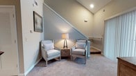 Located in Charleston, SC, this two-story home on Magwood Road offers a thoughtfully designed layout across two levels. The main level features a galley-style kitchen equipped with rich dark wood cabinetry, granite countertops, light wood-look flooring, and a full suite of stainless steel appliances including a refrigerator, range, microwave, and dishwasher. Track lighting illuminates the workspace efficiently. A welcoming entryway with hardwood-style flooring and a decorative accent table connects the main living areas seamlessly. The upper level includes a comfortable sitting nook at the top of the staircase, highlighted by vaulted ceilings and plush carpet — an ideal spot for relaxing. Multiple bedrooms feature soft carpet flooring, ceiling fans, and generous windows that invite natural light and views of the surrounding greenery. The bathrooms are finished with warm neutral tones, dark wood vanities, white countertops, and a standout patterned tile floor that adds a decorative touch. Each bathroom includes a tub-shower combination with a clean white curtain and chrome fixtures. Throughout the home, a consistent neutral color palette and warm finishes create a cohesive and inviting atmosphere.
