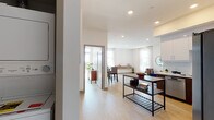 Located at 1265 Stearns Dr in Los Angeles, this modern single-floor residence offers a thoughtfully designed open layout with clean lines and contemporary finishes throughout. Light wood-style flooring flows seamlessly across the living spaces, complemented by bright white walls and recessed lighting that create a fresh, airy ambiance.

The living room is generously proportioned, featuring large windows dressed with sheer curtains that invite abundant natural light. The kitchen is outfitted with stainless steel appliances, including a gas range, microwave, and refrigerator, alongside white upper cabinetry, dark wood lower cabinets, and a tile backsplash with white quartz countertops.

The dining area provides an inviting space for entertaining, with natural light streaming through nearby windows. Two well-sized bedrooms offer comfortable retreats; the primary bedroom includes a private balcony accessible through sliding glass doors, offering open city views. The bathroom is finished with a dual-sink vanity, dark wood cabinetry, a walk-in shower, and an LED-lit mirror, with direct access to a walk-in closet. A stacked in-unit washer and dryer adds everyday convenience. The overall aesthetic balances modern functionality with a warm, livable character.