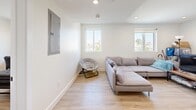 Located in Los Angeles, CA, this two-story home offers seven bedrooms and seven bathrooms across two floors, making it well-suited for large households or co-living arrangements. The ground floor hosts the main shared spaces, including an open-concept kitchen, dining room, and living room. The kitchen is outfitted with white shaker-style cabinetry, white quartz countertops, a classic subway tile backsplash, and a full suite of stainless steel appliances including a gas range, dishwasher, and a large French door refrigerator. Light wood-tone flooring runs throughout, complementing the bright, white-painted walls. The living and dining area is spacious and airy, with recessed lighting and windows that bring in natural light and neighborhood views. Each of the seven bedrooms is a private, well-proportioned room with its own window and access to natural light. The bedrooms share a clean, modern aesthetic with the same light flooring and neutral walls. All seven bathrooms feature white tile surrounds, clean fixtures, and windows for ventilation. Three closets and a hallway provide additional storage and circulation. A staircase connects both floors, with the upper level offering additional bedrooms in a quieter setting above the main living areas.