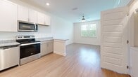 Located in Spring Hill, TN, this one-bedroom, one-bathroom unit offers a well-designed single-floor layout that maximizes every square foot. Light hardwood-style flooring flows seamlessly throughout the entire space, creating a cohesive and bright atmosphere.

The open-concept kitchen and living area form the heart of the unit. The kitchen is outfitted with white upper cabinetry, grey lower cabinets, granite countertops, a peninsula island for additional prep or seating space, and stainless steel appliances including a refrigerator, electric range, and microwave. Recessed lighting and a ceiling fan illuminate the combined living area, while a window overlooking greenery fills the space with natural light.

The bedroom is a comfortable, well-proportioned room featuring a ceiling fan, a window with outdoor views of lush trees, and access to a walk-in closet with built-in shelving and mirrored doors — providing excellent storage.

The bathroom is clean and modern, featuring a tiled tub-shower combination, a single-sink vanity with granite countertops and grey cabinetry, brushed nickel hardware, and a large mirror. The hardwood-style flooring continues here, tying the aesthetic together. The unit also includes an electrical panel conveniently located in the bedroom hallway.