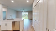 Located at 11305 Grant Rd in Houston, TX, this single-story, one-bedroom, one-bathroom unit offers a thoughtfully designed layout with modern finishes throughout. Light-toned hardwood flooring flows seamlessly across the entire space, creating a cohesive and clean aesthetic.

The open-concept kitchen serves as a centerpiece, featuring crisp white shaker cabinetry extending to the ceiling, granite countertops, a subway tile backsplash, and a large central island with a built-in sink. Stainless steel appliances, including a French door refrigerator, electric range, and over-the-range microwave, complete the space.

The living area is bright and airy, with a ceiling fan and sliding glass doors that open to a view of the lush, well-maintained green grounds enclosed by an iron fence.

The bedroom is comfortably sized, offering a ceiling fan, a window with outdoor views, and access to a walk-in closet equipped with wire shelving and hanging rods for ample storage.

The bathroom is elegantly finished with large-format marble-style tile surrounding a soaking tub and shower combo, a granite-topped white vanity, and coordinating hardwood flooring. The overall ambiance is clean, modern, and move-in ready.