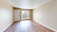 Located at 1628 Bell St in Arden-Arcade, CA, this one-bedroom, two-bathroom single-story unit offers a practical and comfortable layout across a well-utilized floor plan. The open-concept living, dining, and kitchen area serves as the heart of the home, finished with rich wood-style flooring and neutral warm-beige walls that create a cohesive, inviting atmosphere. A ceiling fan with light fixture adds both function and comfort to the living space, which receives natural light through a large window fitted with vertical blinds. The kitchen features a peninsula with granite-style countertops, white cabinetry extending to the ceiling for ample storage, a white range, and a full-size refrigerator — all oriented to support easy interaction with the living and dining areas. A hallway connects the main living space to the private areas of the unit, leading to the generously sized bedroom, which is carpeted and brightened by a large window. The bedroom includes access to two closets, one of which is a sizable walk-in with built-in shelving and hanging rods. Both bathrooms are finished with wood-style flooring, white vanity cabinetry, and granite-style countertops, with one featuring a full tub-shower combination. A dedicated utility room accommodates a stacked washer and dryer, adding everyday convenience to this well-appointed home.