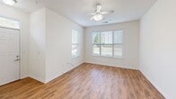 This single-floor residence at 5000 Tazewell Pike in Knoxville, Tennessee offers a well-designed layout with a clean, modern aesthetic throughout. The open-concept living and dining area features warm wood-look flooring, crisp white walls, and a ceiling fan, creating a bright and welcoming atmosphere. Natural light flows in through multiple windows fitted with blinds, offering pleasant outdoor views.

The kitchen is a functional centerpiece, equipped with rich wood cabinetry, granite countertops, and a full suite of stainless steel appliances including a refrigerator, range, microwave, and dishwasher. A granite-topped island with pendant lighting above serves as both a workspace and a natural divider between the kitchen and living areas.

The bedrooms are generously proportioned, each featuring ceiling fans and windows that invite natural light. Select bedrooms are finished with plush carpeting, while others continue the wood-look flooring found in the main living spaces. Arched interior doorways add an architectural touch throughout the unit.

The bathroom includes a wood-vanity with a dark granite countertop, a large mirror, and access to a walk-in closet with built-in shelving. Additional utility space is visible, adding practical storage capacity. Overall, the space is thoughtfully laid out and finished with consistent, quality materials from room to room.