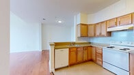 Located at 50 S Highland Ave in West York, PA, this three-bedroom, one-bathroom home offers a practical and comfortable layout across a single floor. The combined kitchen and living room serves as the heart of the home, with warm hardwood flooring that extends throughout the main living areas. The kitchen is well-equipped with ample warm-toned wood cabinetry, generous counter space, and white appliances including a range, dishwasher, and refrigerator, all set on easy-care tile flooring. The living area benefits from an open feel with clean white walls and good natural light. Each of the three bedrooms features plush carpet flooring and bright white walls. The bedrooms are generously proportioned, with the primary bedroom offering notable space and access to a dedicated closet. Additional closet storage is also available elsewhere in the unit. A second walk-in style closet features wire shelving and hardwood flooring. The full bathroom is finished with classic light blue tile surrounding a soaking tub and shower, complemented by a wood-cabinet vanity and a medicine cabinet mirror. Throughout the home, large gridded windows allow natural light to filter in, offering views of the surrounding West York area and contributing to a bright, airy atmosphere.