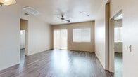 This single-story home offers a well-organized layout across three bedrooms, one bathroom, a kitchen, hallway, and closet. The living area is a standout feature, showcasing wood-style flooring, a ceiling fan, and generous natural light through sliding glass doors fitted with vertical blinds and a large window — creating a bright, open atmosphere.

The kitchen is appointed with rich dark-wood cabinetry, light countertops, a peninsula for additional workspace, and stainless steel appliances including a refrigerator, range, microwave, and dishwasher. A window above the sink adds natural light to the functional workspace.

The primary bedroom is notably spacious, featuring dual windows, a ceiling fan, and the same wood-style flooring found throughout the home. The additional bedrooms are well-proportioned, each with windows fitted with blinds to control natural light. The bathroom includes a walk-in shower with built-in shelving and tile surround, complemented by wood-style tile flooring. Consistent warm neutral tones and wood-style flooring unify the home, creating a cohesive and clean aesthetic throughout.