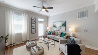 This single-story, two-bedroom, two-bathroom residence offers a thoughtfully designed open-concept layout that connects the living, dining, and kitchen areas into one cohesive space. The living room is bright and welcoming, featuring a ceiling fan with light fixture, neutral gray walls, and large windows with transom detailing that allow generous natural light to fill the room. Wood-style flooring extends throughout the main living areas, providing a warm, consistent aesthetic.

The kitchen is equipped with dark espresso cabinetry, granite-style countertops, and stainless steel appliances, including a refrigerator, range, and built-in microwave. A pass-through opening connects the kitchen to the dining area, enhancing the open feel of the shared living space.

Both bedrooms are carpeted and feature ceiling fans, windows with blinds, and arched doorways. Each room offers a calm, restful atmosphere with soft neutral tones.

The two bathrooms are finished with dark cabinetry, granite-topped vanities, wood-style flooring, and tub-shower combinations. One bathroom features a large vanity mirror and coordinating fixtures, while the second presents a clean, straightforward layout with a curved shower rod.

Overall, the residence presents a modern, comfortable design with consistent finishes throughout.