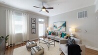 This single-story, two-bedroom, two-bathroom residence offers a thoughtfully designed open-concept layout that connects the living, dining, and kitchen areas into one cohesive space. The living room is bright and welcoming, featuring a ceiling fan with light fixture, neutral gray walls, and large windows with transom detailing that allow generous natural light to fill the room. Wood-style flooring extends throughout the main living areas, providing a warm, consistent aesthetic.

The kitchen is equipped with dark espresso cabinetry, granite-style countertops, and stainless steel appliances, including a refrigerator, range, and built-in microwave. A pass-through opening connects the kitchen to the dining area, enhancing the open feel of the shared living space.

Both bedrooms are carpeted and feature ceiling fans, windows with blinds, and arched doorways. Each room offers a calm, restful atmosphere with soft neutral tones.

The two bathrooms are finished with dark cabinetry, granite-topped vanities, wood-style flooring, and tub-shower combinations. One bathroom features a large vanity mirror and coordinating fixtures, while the second presents a clean, straightforward layout with a curved shower rod.

Overall, the residence presents a modern, comfortable design with consistent finishes throughout.