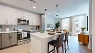 Located at 1133 Harding Place in Charlotte's vibrant 28204 zip code, this single-floor residence showcases a thoughtfully designed open-concept layout with contemporary finishes throughout. The kitchen is a standout feature, equipped with stainless steel appliances including a French door refrigerator, microwave, and range, complemented by two-tone cabinetry — crisp white uppers paired with warm gray lowers — and a light gray tile backsplash. A central island with white quartz countertops and seating for two serves as both a functional workspace and a casual dining area, illuminated by sleek pendant lighting overhead. Light wood-style flooring flows seamlessly into the living area, where large windows and a glass door flood the space with natural light and provide access to a private balcony. The living room offers an inviting atmosphere with clean white walls that provide a neutral backdrop. The bedrooms are well-proportioned, each featuring ceiling fans, ample natural light, and a calm, restful aesthetic. The primary bathroom is finished with floor-to-ceiling rectangular tile in the walk-in shower, matte black fixtures, and a frameless glass enclosure, delivering a clean, spa-inspired feel. Built-in shelving and thoughtful storage details complete this well-appointed home.