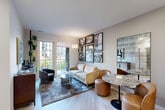 Located at Fox Valley Center Drive in Aurora, IL, this one-bedroom, one-bathroom residence offers a thoughtfully designed layout with modern finishes throughout. The open-concept living and kitchen area serves as the heart of the home, featuring light hardwood-style flooring that flows seamlessly between spaces. The kitchen stands out with bold navy cabinetry extending to the ceiling, a white quartz countertop island with bar seating, stainless steel appliances, a subway tile backsplash, and recessed lighting — a highly functional and visually striking space. The living room is bright and inviting, anchored by a curated gallery wall of black-and-white framed artwork and a large sliding glass door that opens onto a private balcony with outdoor views. The bedroom offers plush carpeting, a dedicated walk-in closet, and a calm, restful atmosphere. The bathroom is clean and contemporary, featuring a navy vanity with a marble-look countertop, a backlit vanity mirror, and a glass-enclosed walk-in shower with tile surround. Throughout the residence, a neutral color palette, contemporary fixtures, and carefully considered details create a cohesive, upscale ambiance well-suited for modern living.